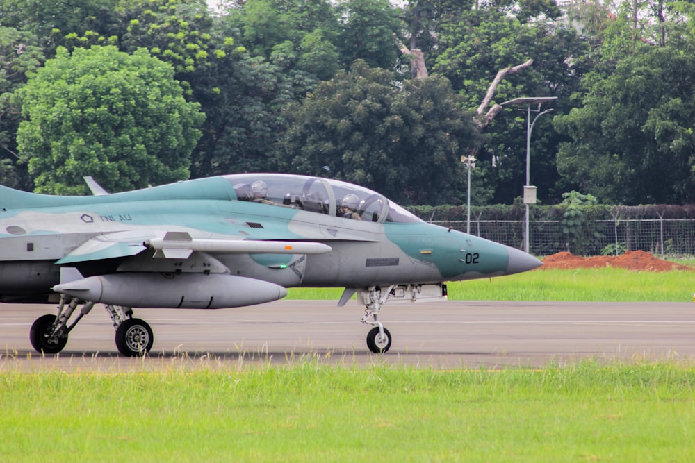 a fighter jet sitting on top of an airport runway