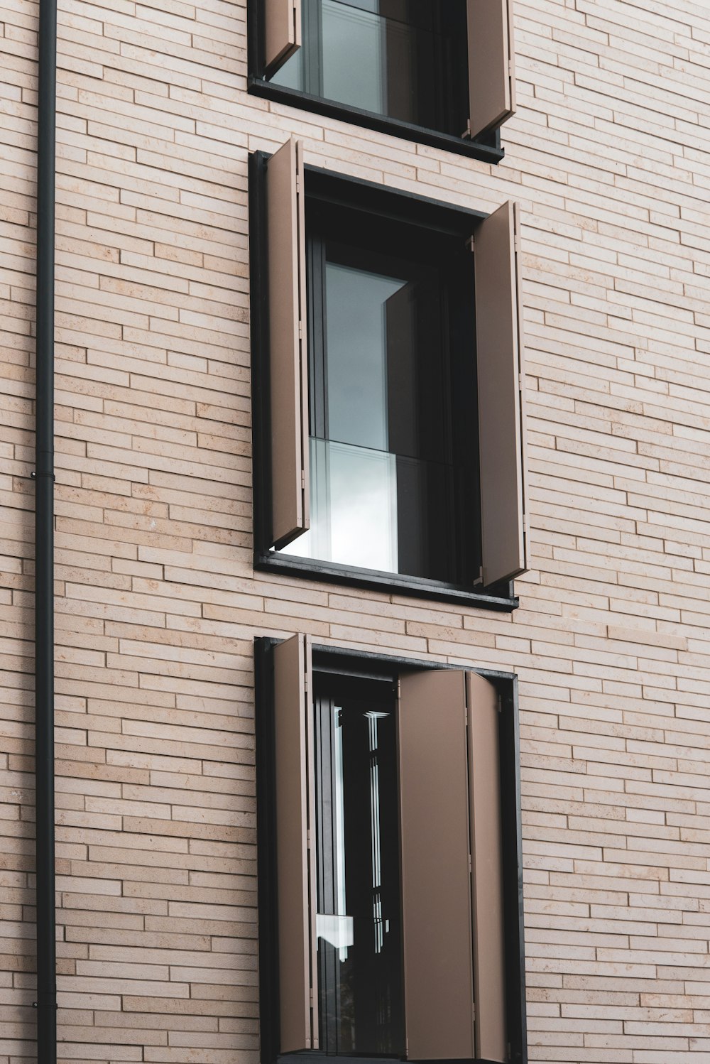 a tall brick building with two windows and a clock