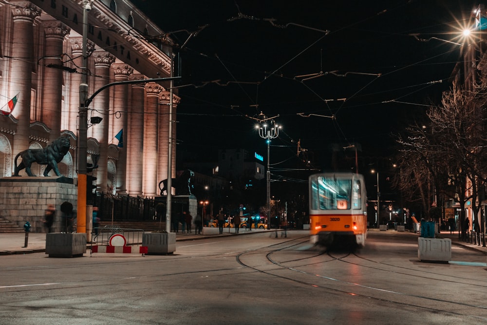 a train traveling down a street next to tall buildings