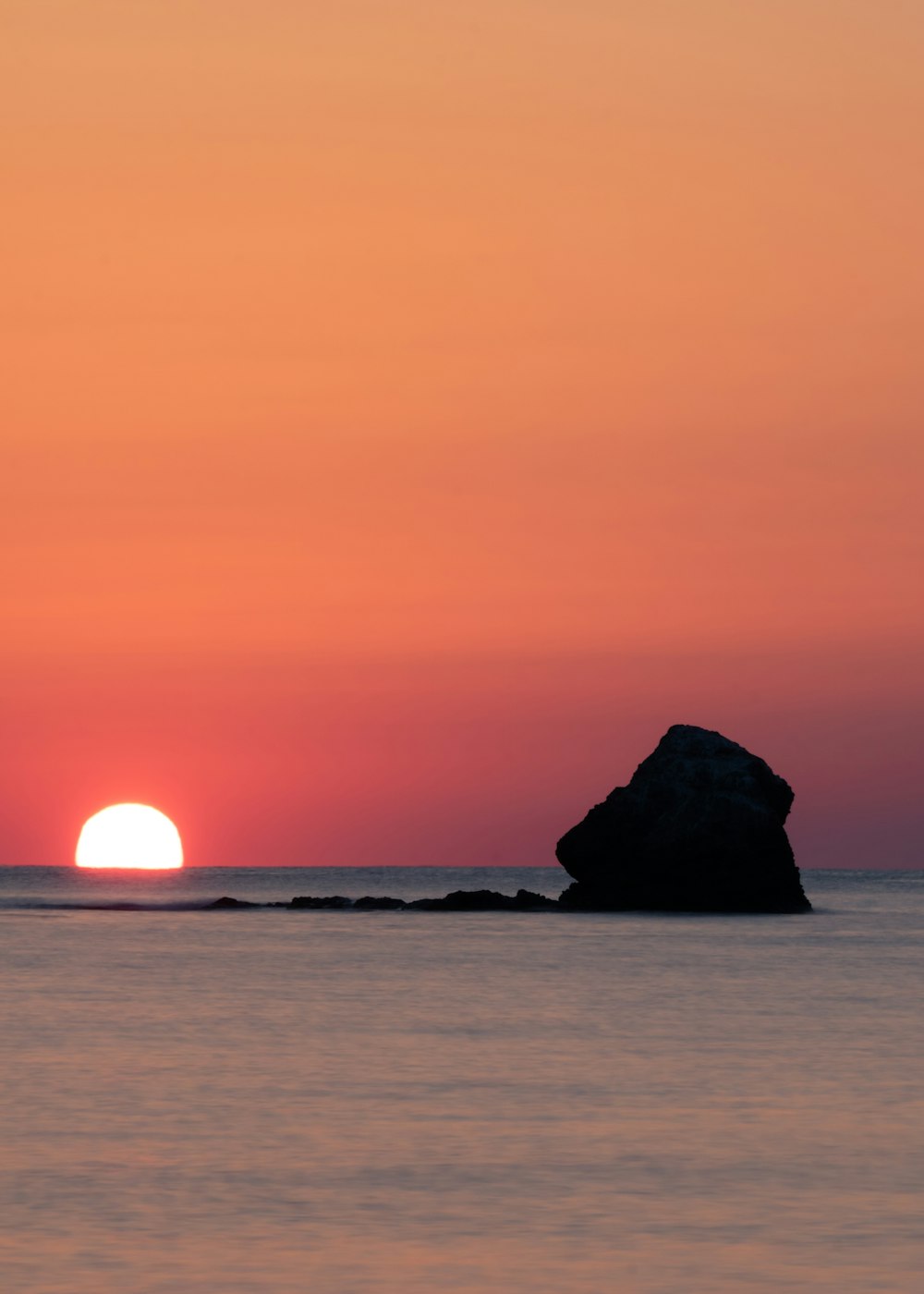 a large rock in the middle of a body of water