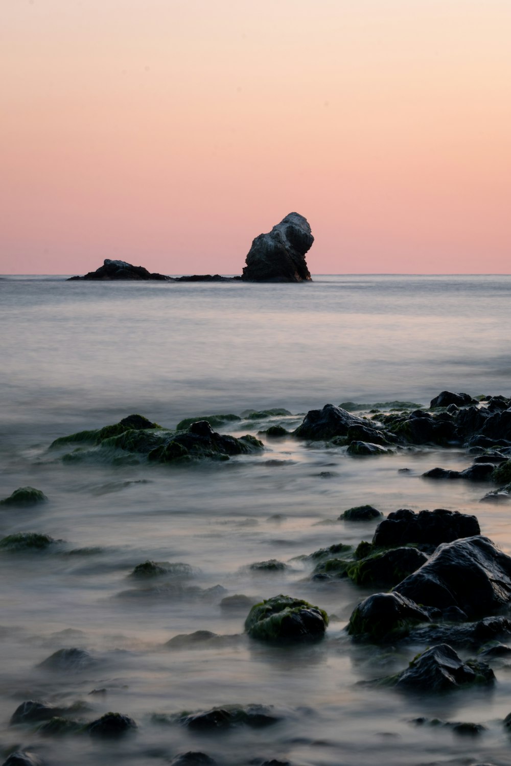 a large rock in the middle of a body of water