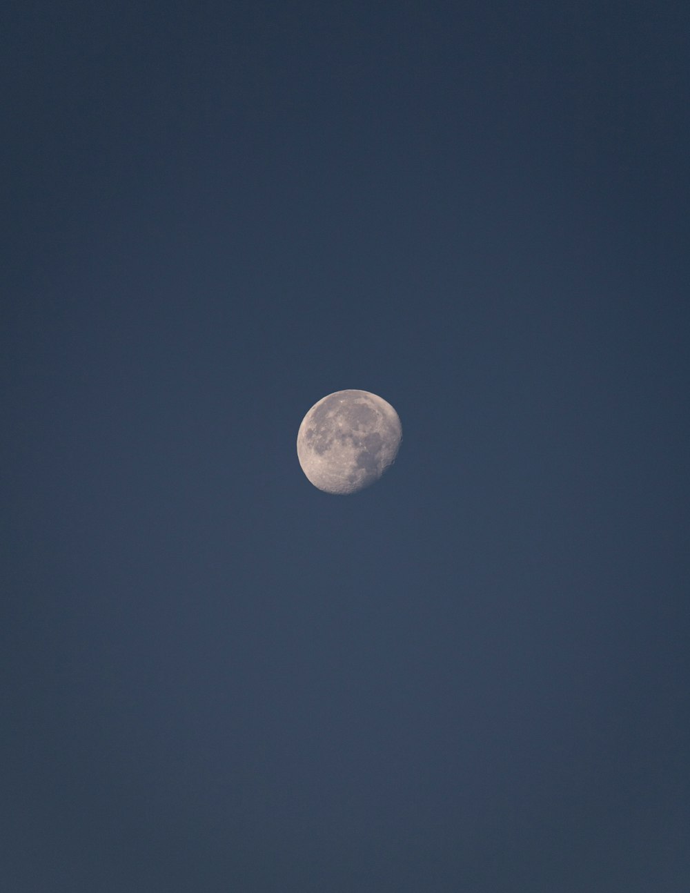 Una luna llena en un cielo azul claro