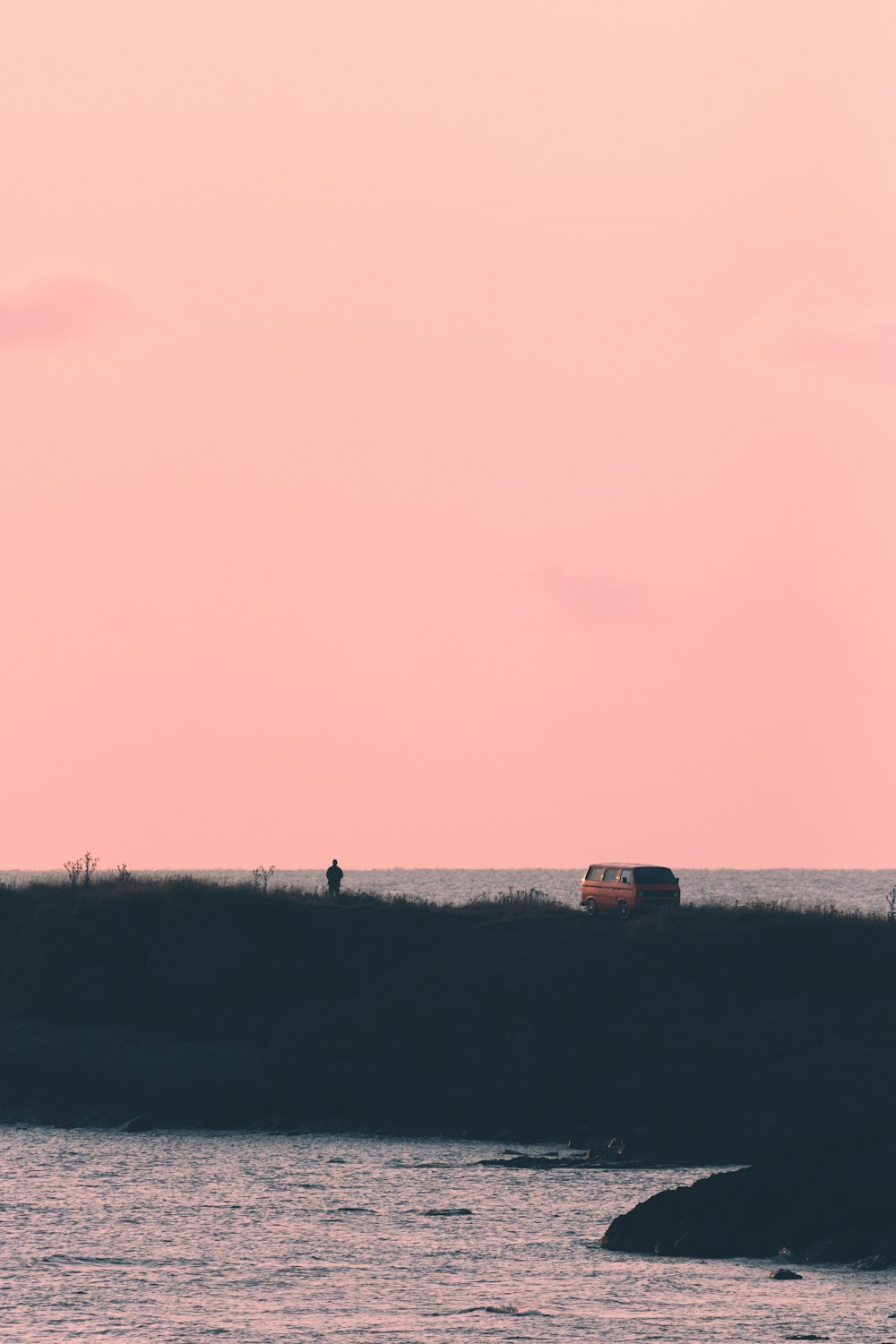 a car driving on a road next to the ocean