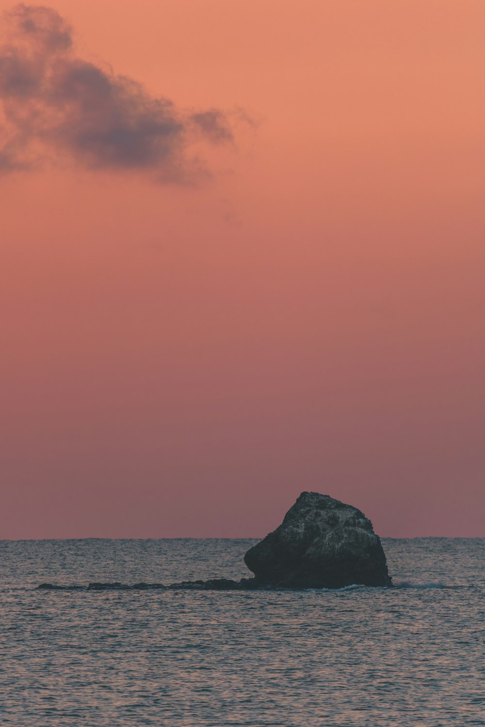 a large rock in the middle of a body of water