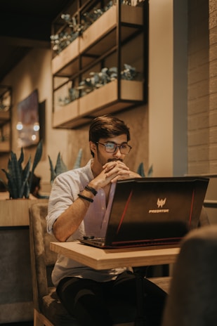 a man sitting at a table using a laptop computer