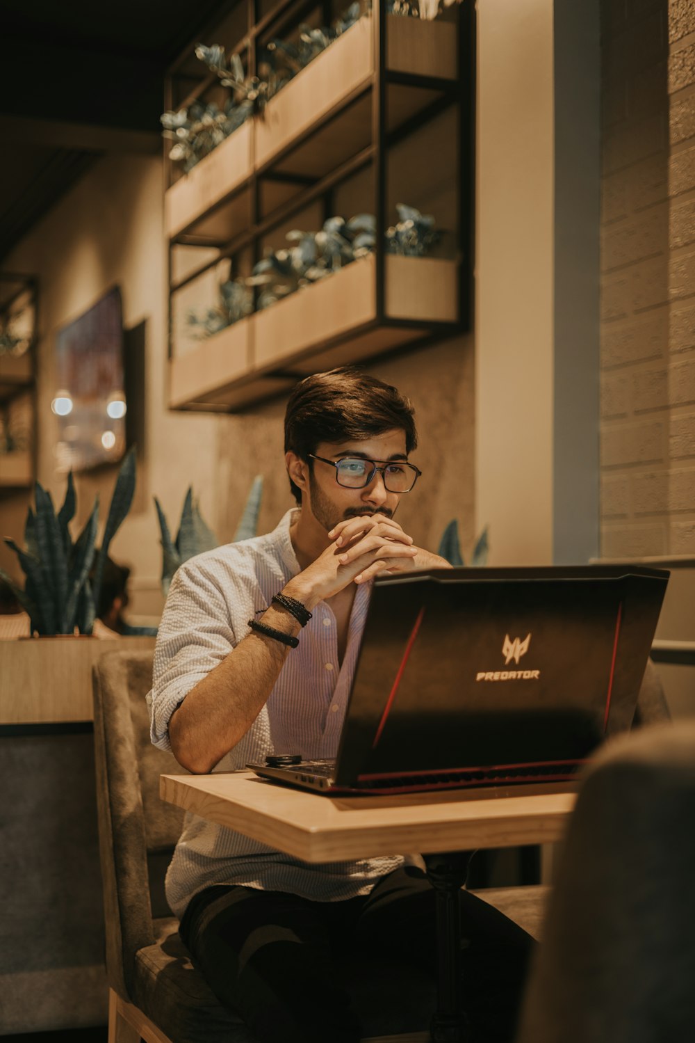 a man sitting at a table using a laptop computer