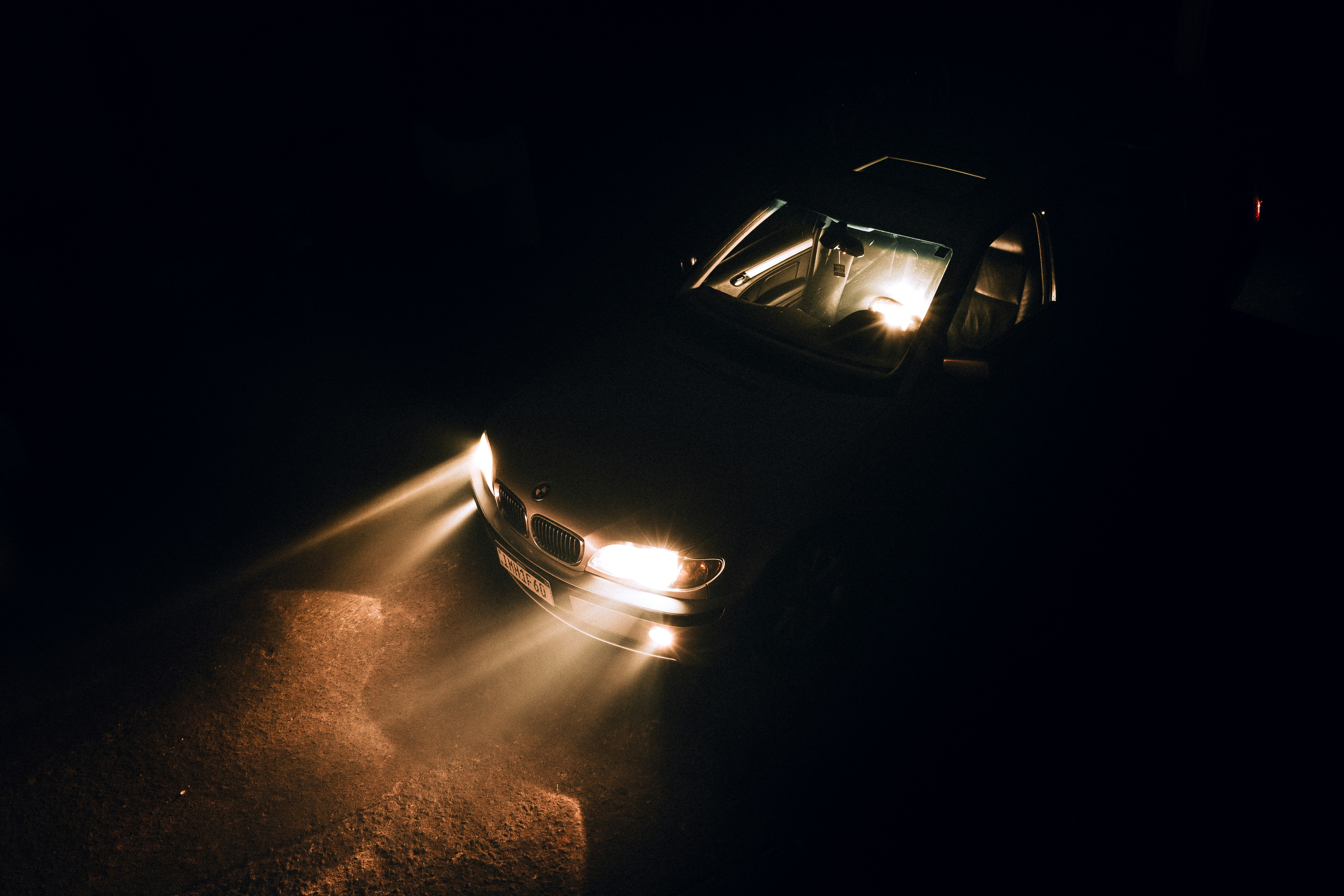 A car with its headlights turned on in the dark