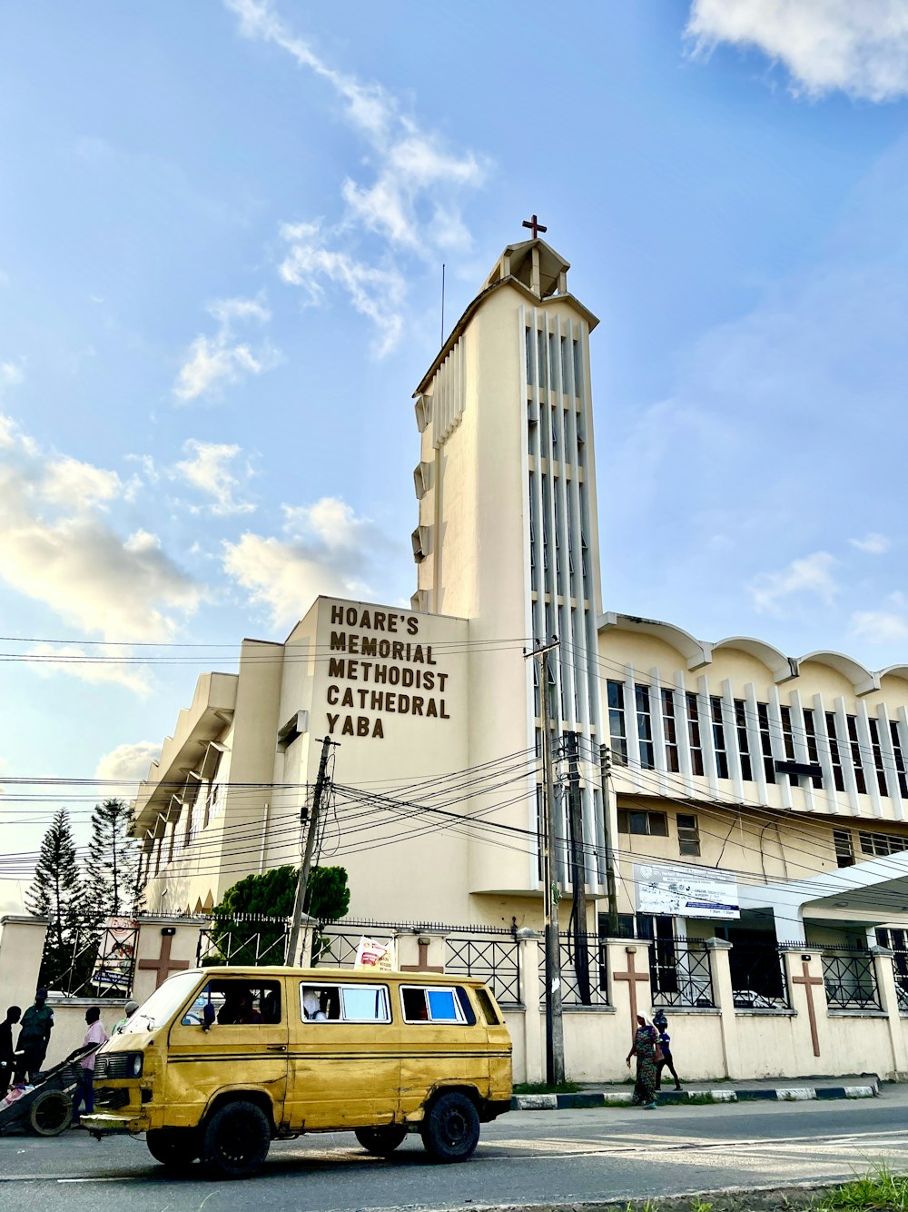 a yellow van parked in front of a tall building