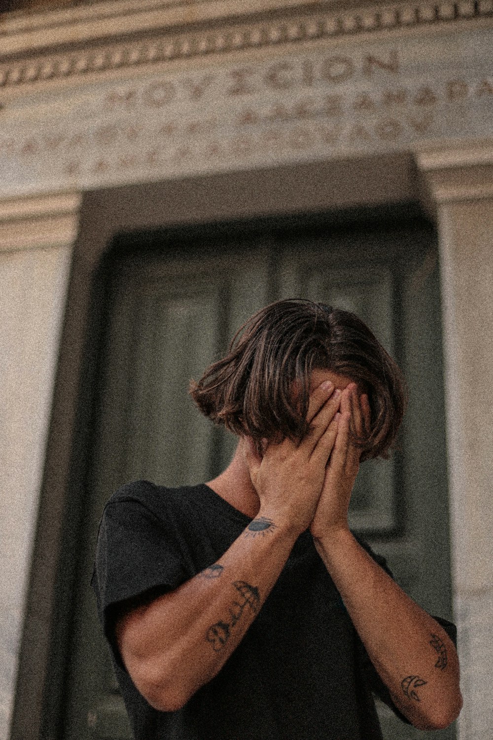 a man covering his face with his hands