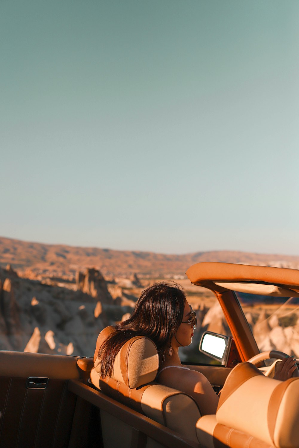 a woman sitting in the back of a convertible car