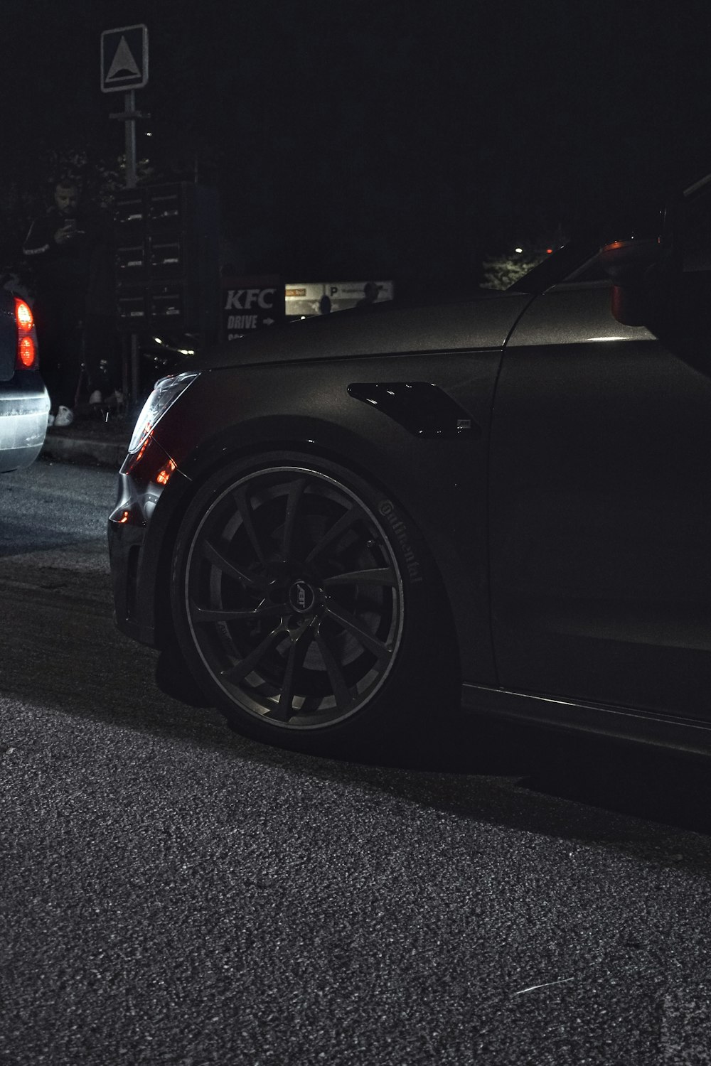 a car parked on the side of the road at night