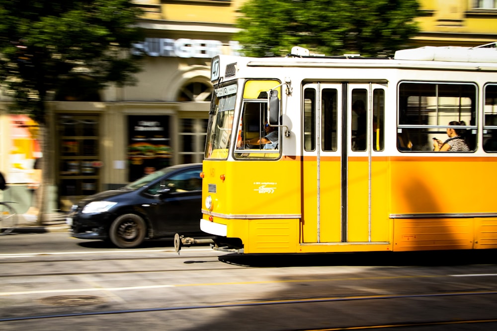 a yellow trolley car traveling down a city street