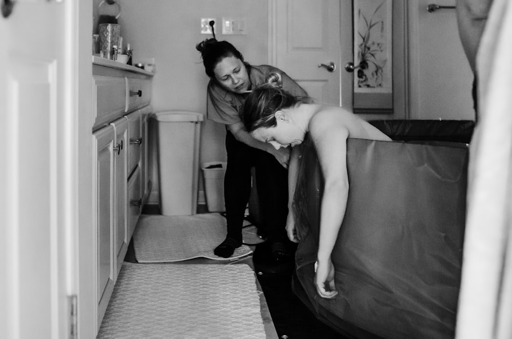 a couple of women standing next to each other in a bathroom