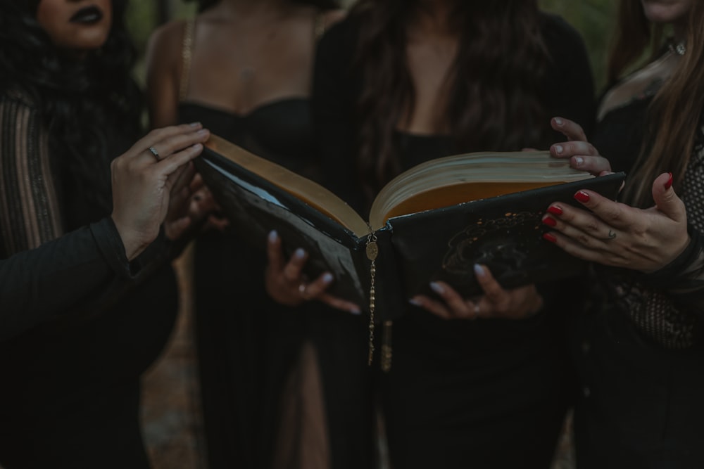 um grupo de mulheres de pé uma ao lado da outra segurando um livro