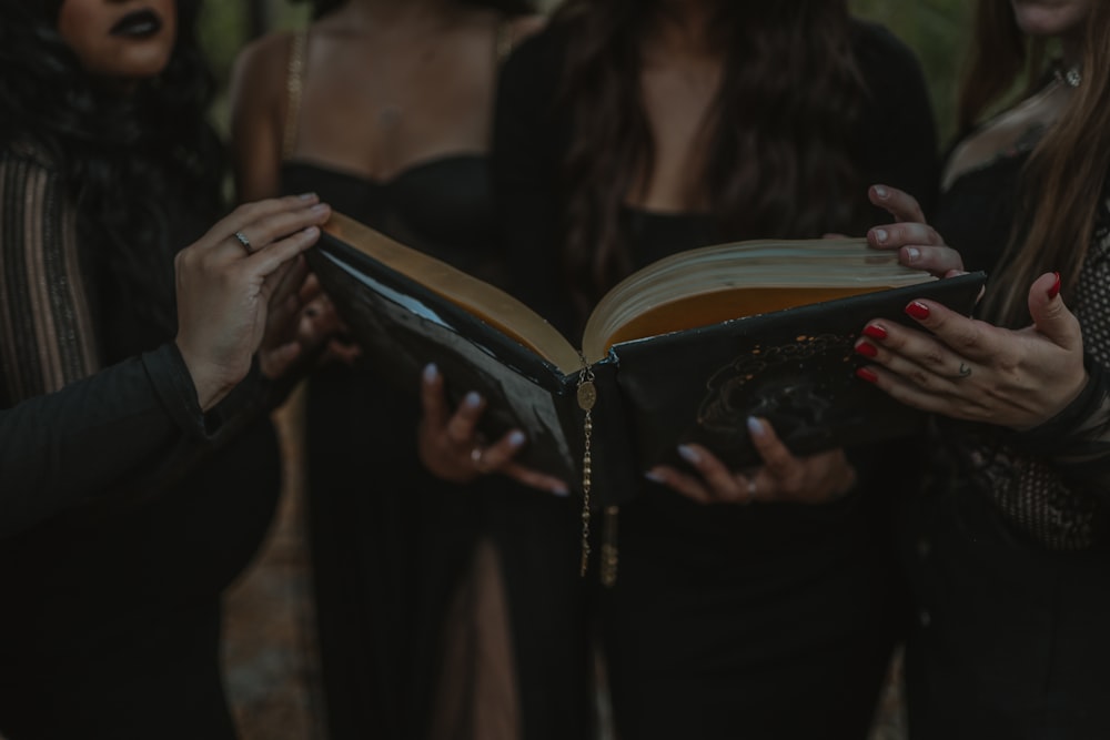 a group of women standing next to each other holding a book
