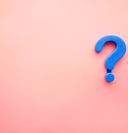 a blue question mark on a pink background