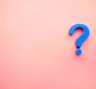 a blue question mark on a pink background