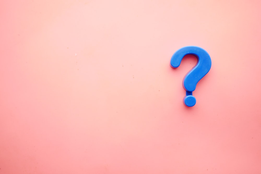 a blue question mark on a pink background