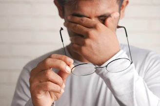 a man holding a pair of glasses up to his face