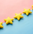 a row of yellow stars sitting on top of a blue and pink surface