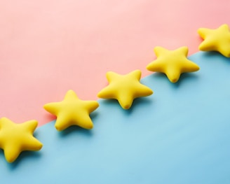 a row of yellow stars sitting on top of a blue and pink surface