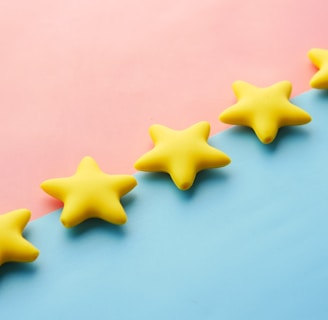 a row of yellow stars sitting on top of a blue and pink surface