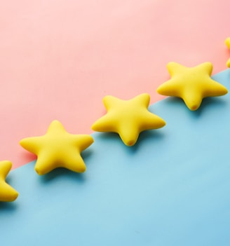 a row of yellow stars sitting on top of a blue and pink surface