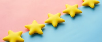 a row of yellow stars sitting on top of a blue and pink surface