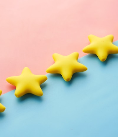 a row of yellow stars sitting on top of a blue and pink surface