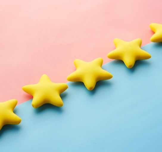 a row of yellow stars sitting on top of a blue and pink surface