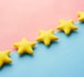 a row of yellow stars sitting on top of a blue and pink surface