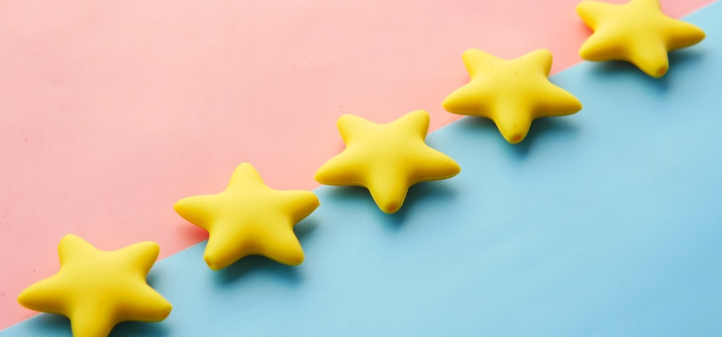 a row of yellow stars sitting on top of a blue and pink surface