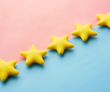 a row of yellow stars sitting on top of a blue and pink surface