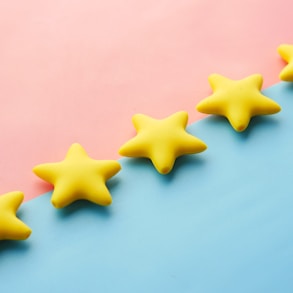 a row of yellow stars sitting on top of a blue and pink surface