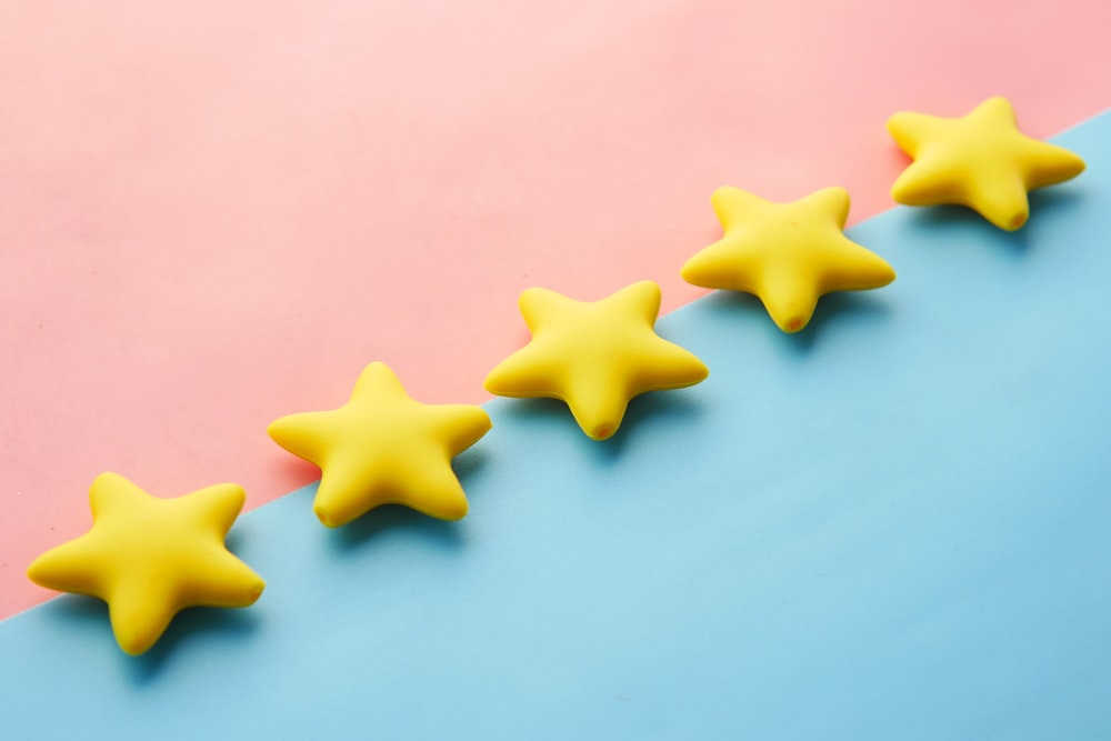 a row of yellow stars sitting on top of a blue and pink surface