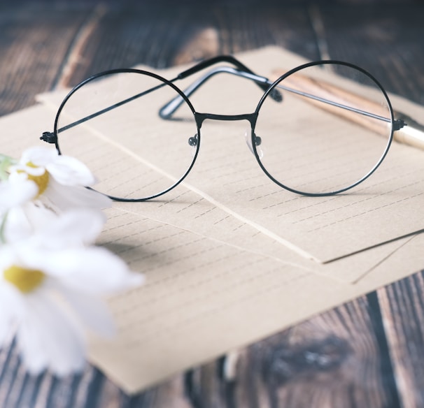 a pair of glasses sitting on top of a piece of paper