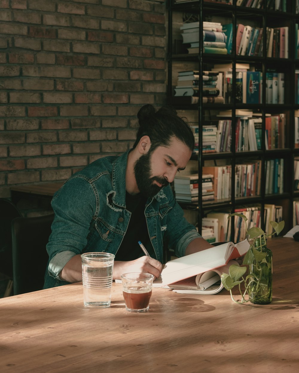 a man sitting at a table writing in a book