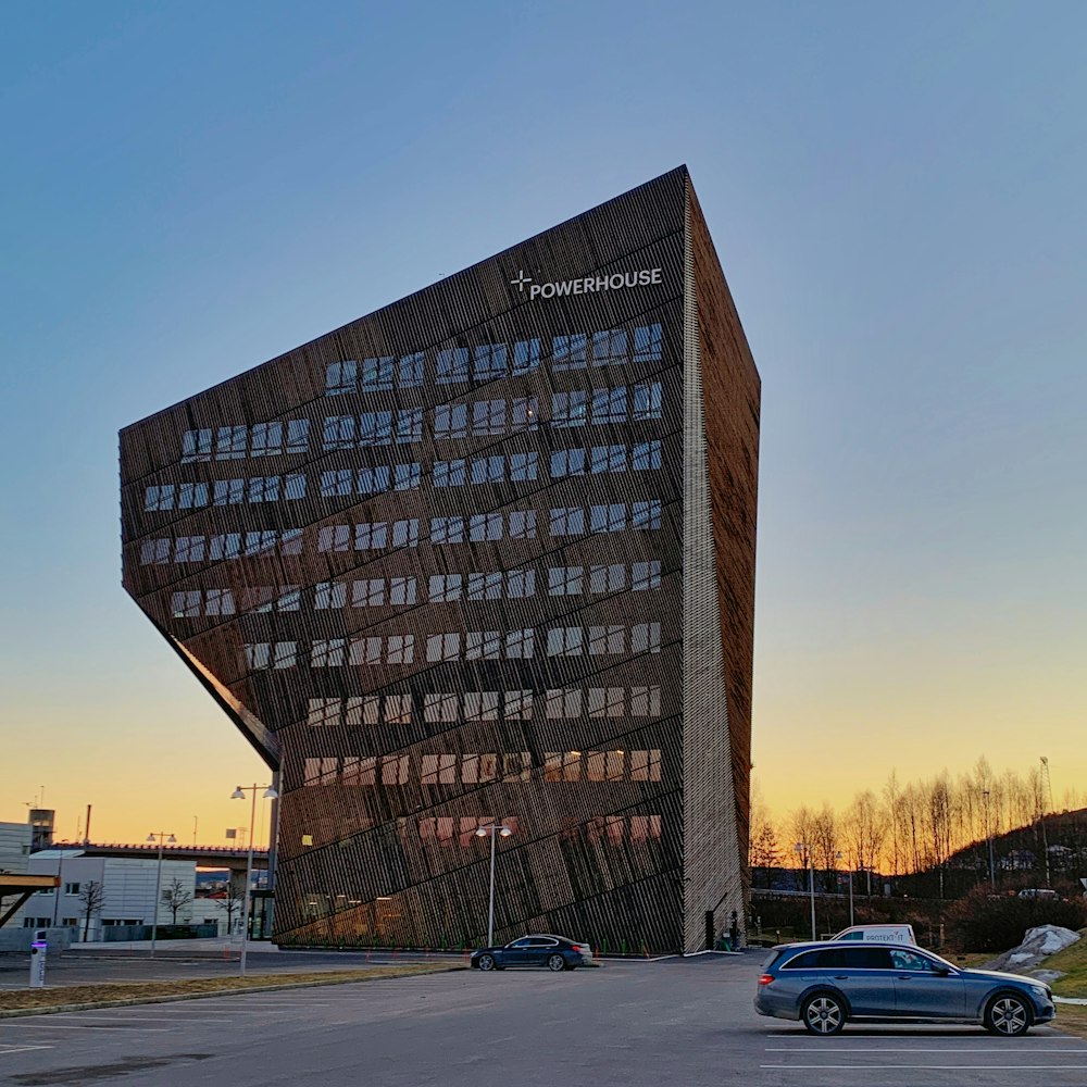 a tall building with many windows next to a parking lot