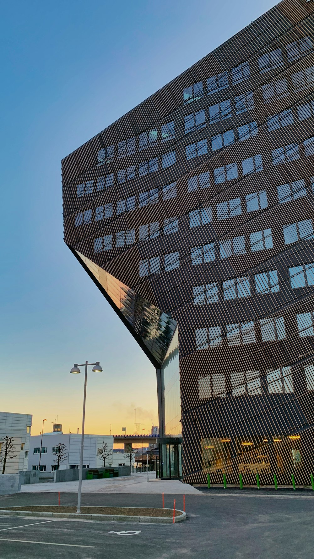 a very tall building with many windows next to a parking lot