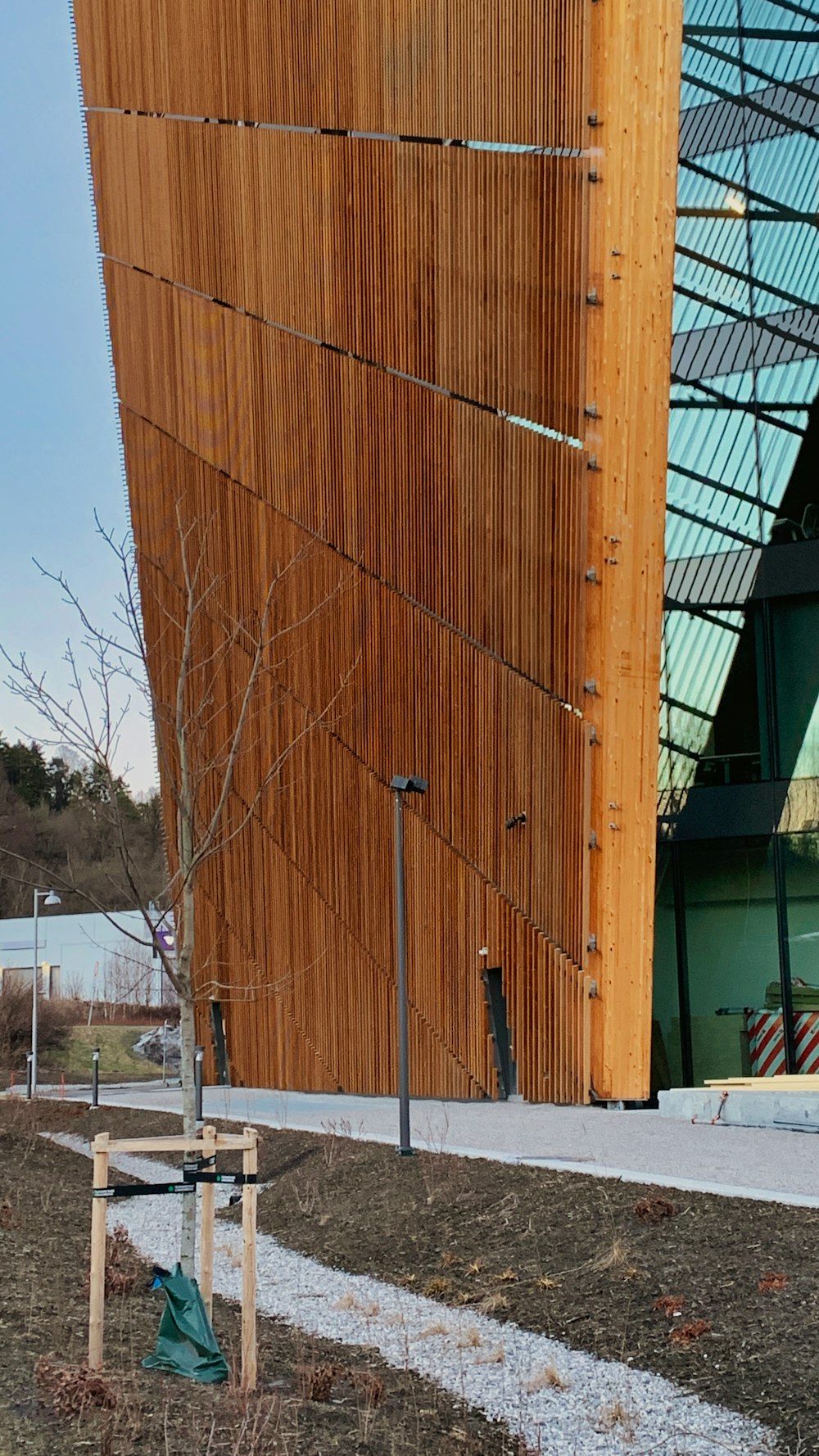 a wooden building with a metal roof next to a tree