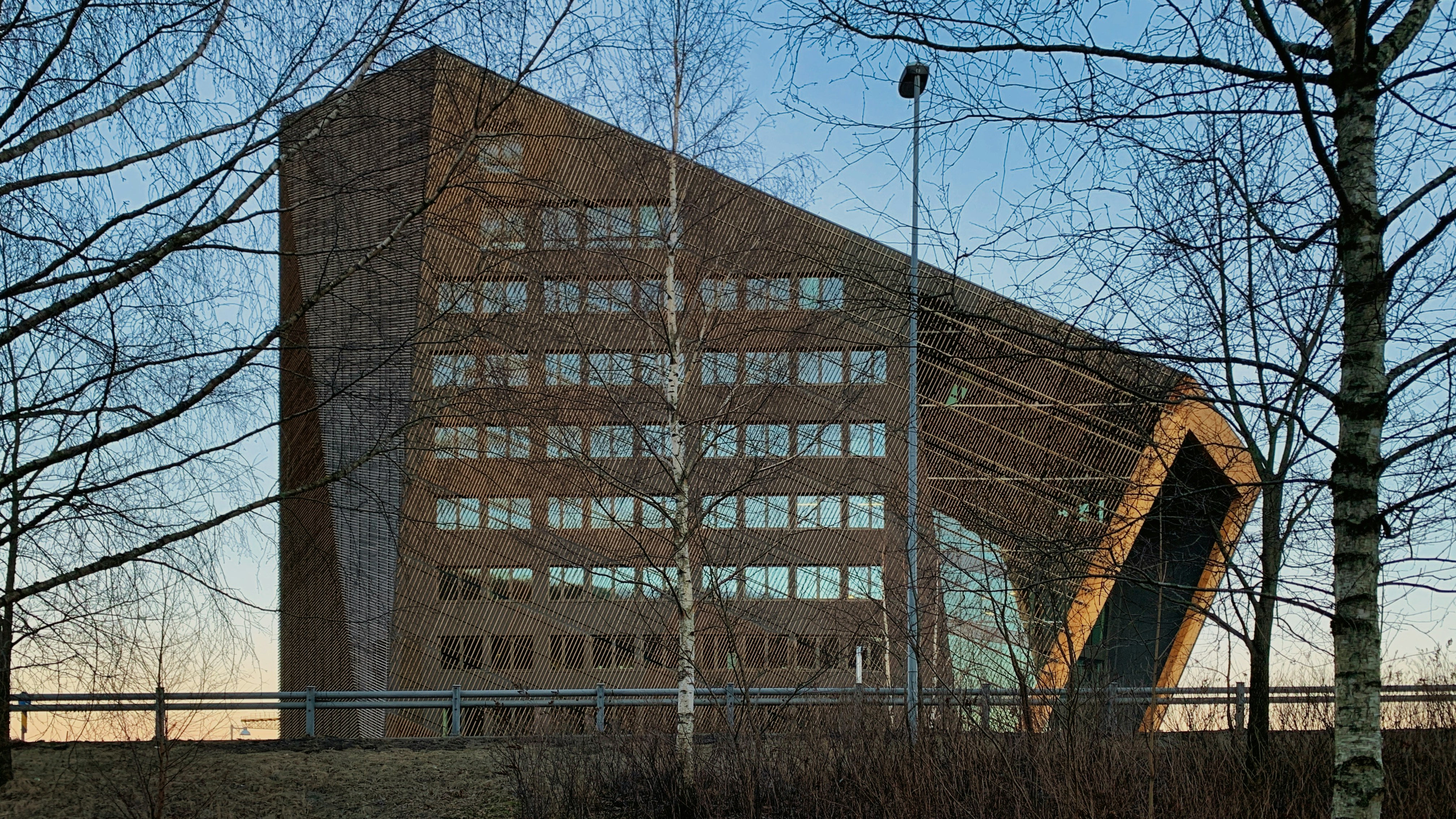 a tall building with a lot of windows next to trees