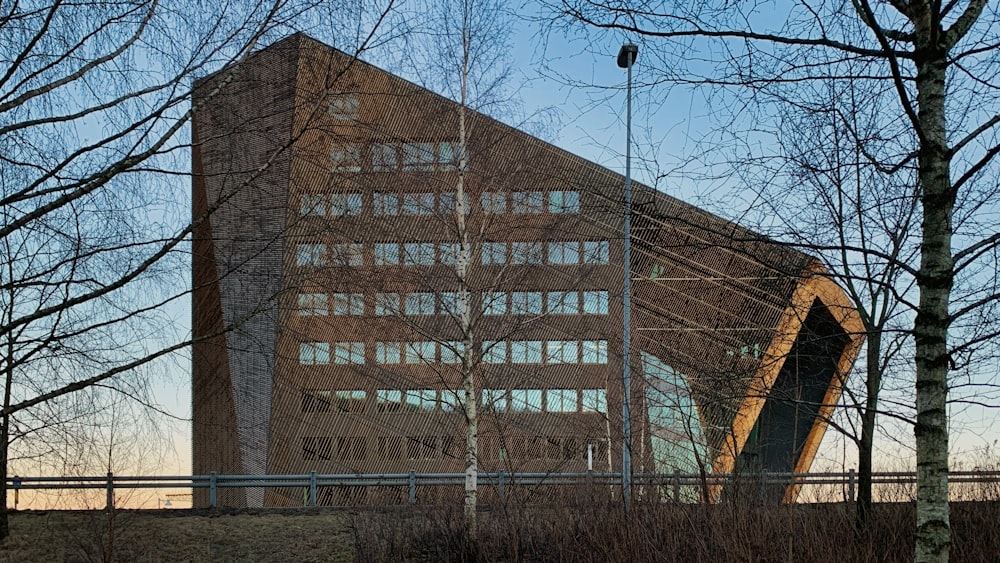 a tall building with a lot of windows next to trees