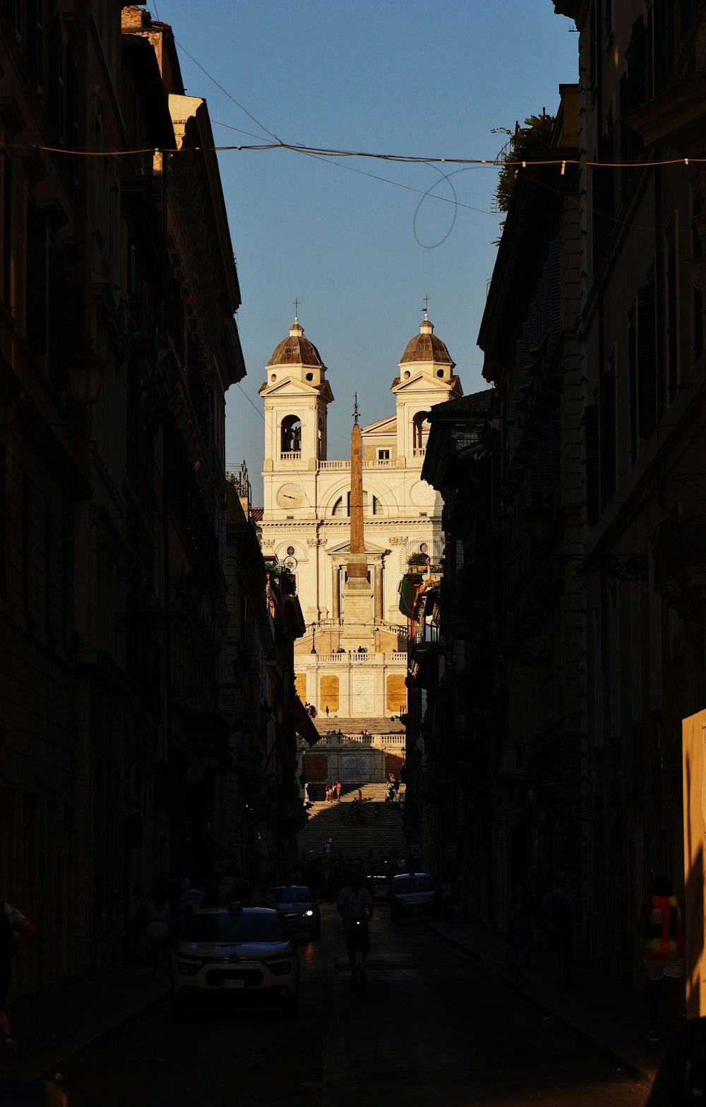 a narrow street with a church in the background