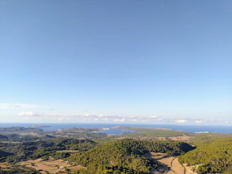 A large plot of land with clear skies, overlooking the river and distant mountains near the coast.