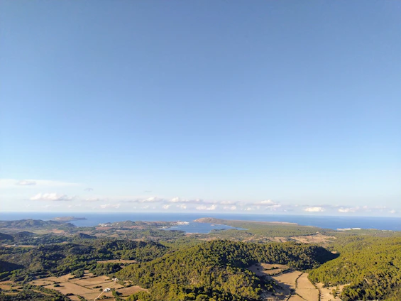 A large plot of land with clear skies, overlooking the river and distant mountains near the coast.