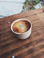 Close-up of a beautifully crafted coffee cup on a wooden table.