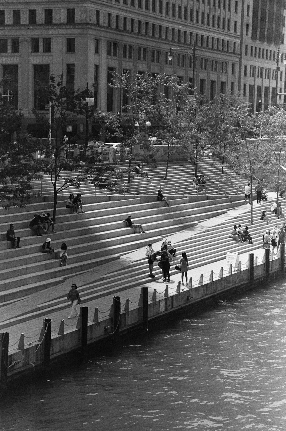 a black and white photo of people sitting on steps