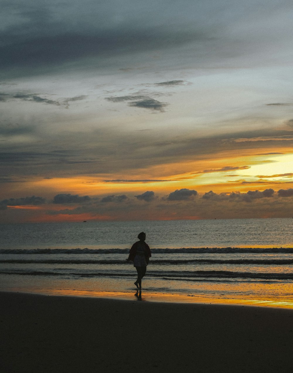 a person walking on a beach with a surfboard