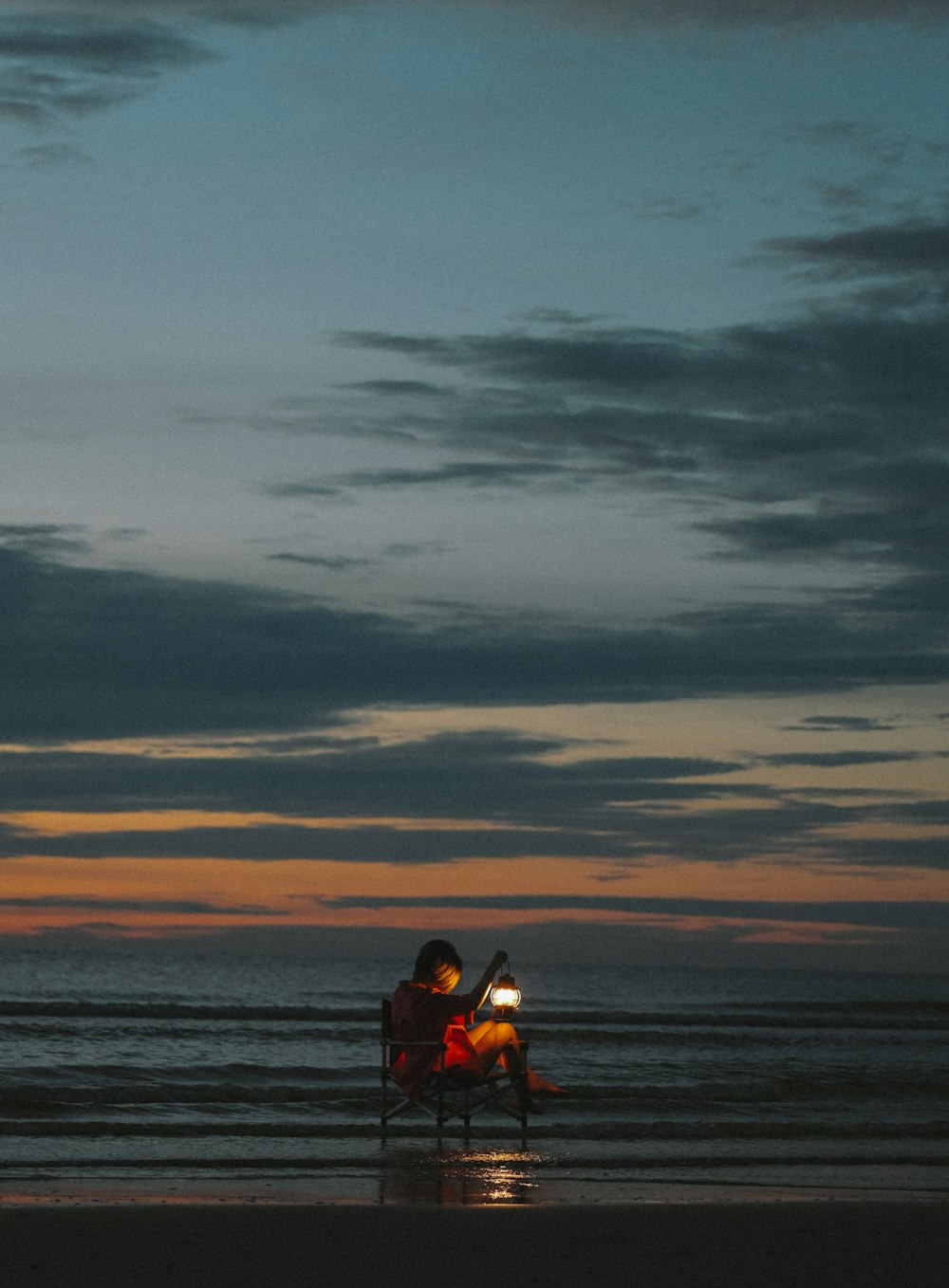 a couple of people sitting on top of a beach