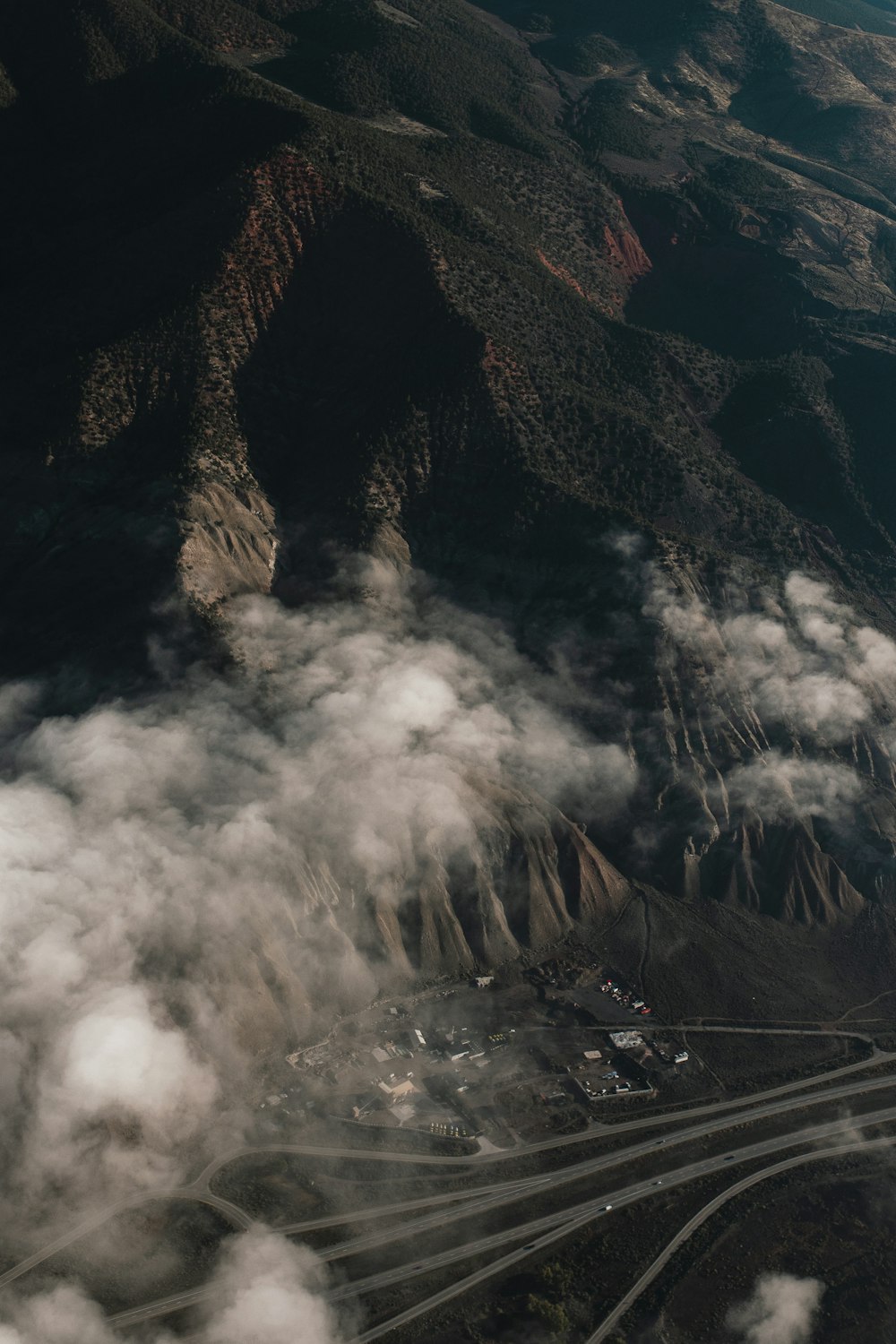 an aerial view of a mountain with clouds